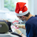 Female child at dentist on Christmas holidays. children’s dentistry. examination of teeth. girl at doctor for new year in Santa hat. oral hygiene training.